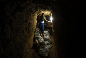 Palestinian smuggler stands next to bags of scrap metal to be exported to Egypt through a tunnel in Rafah.